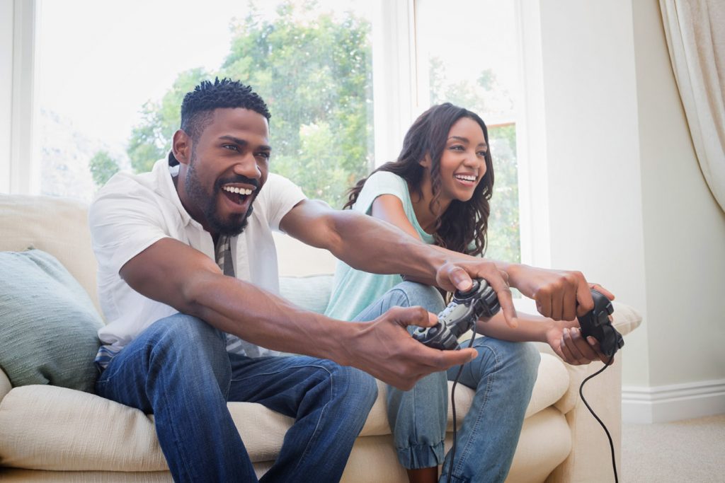 Happy couple on the couch playing video games